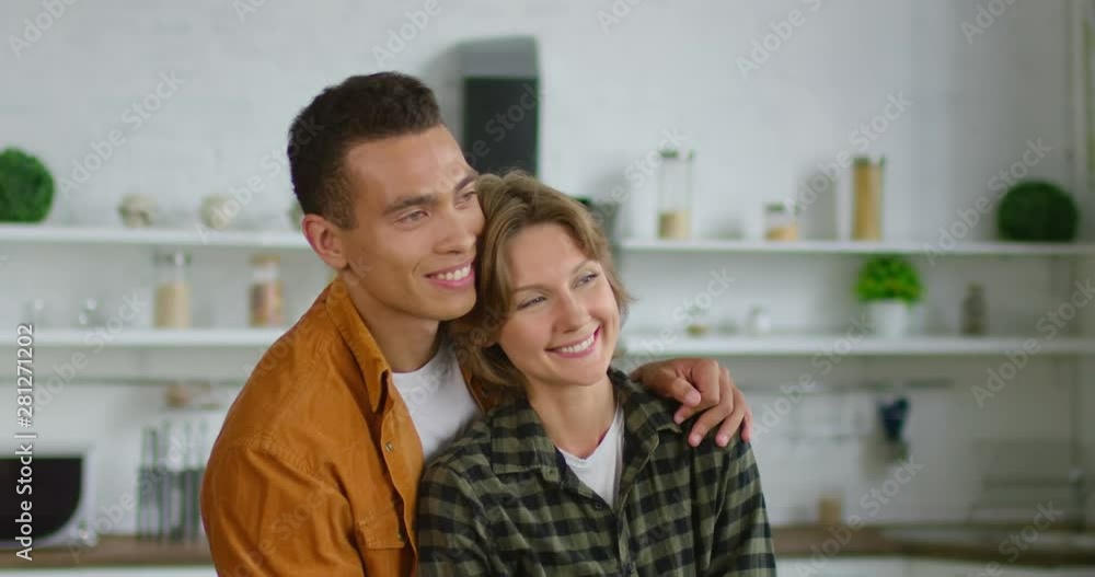 Hispanic man and caucasian woman dancing and hugging in kitchen, being in love, enjoying their relationships, smiling, happy together, in a good mood. 4K, shot on RED camera. Hispanic man and caucasian woman dancing and hugging in kitchen, being in love, enjoying their relationships, smiling, happy together, in a good mood. 4K, shot on RED camera.