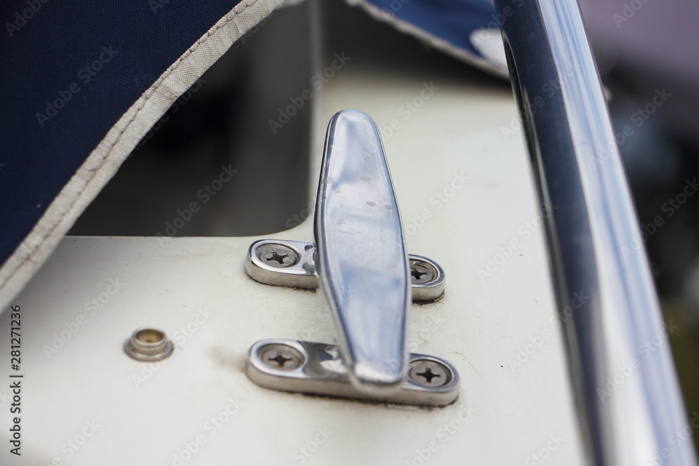 Stainless steel mooring cleat on Board of white motor boat Photos