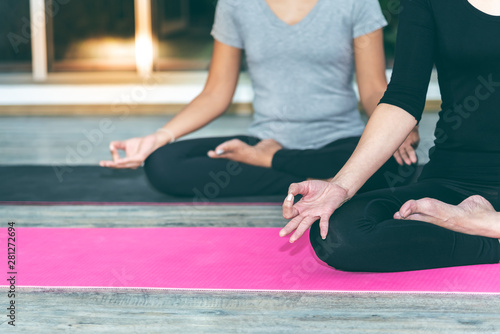Canvas Print Two women are practicing yoga in the basic position, which is a warm-up and medi