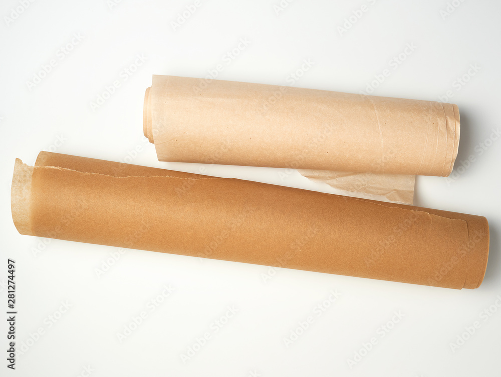 two rolls of brown parchment paper for baking on a white background two rolls of brown parchment paper for baking on a white background