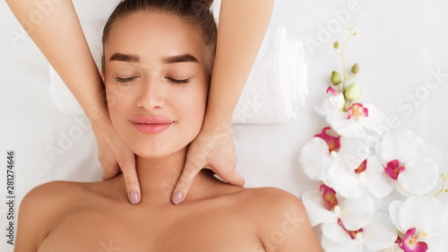 Professional cosmetologist making neck massage to woman