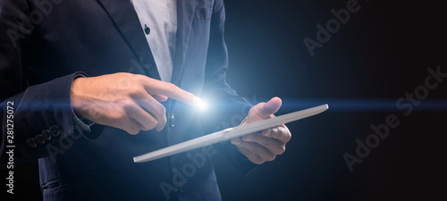 Man with lightng finger touching tablet screen to scroll photo