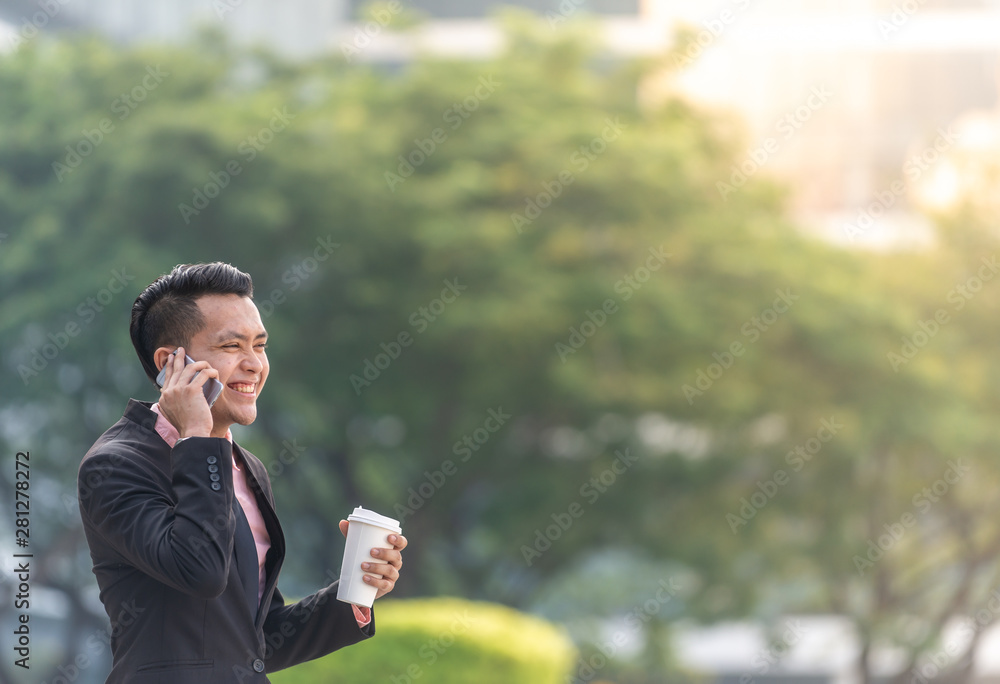 Young Malay Business Man on his Smartphone with a cup of coffee. Copy space for text. Young Malay Business Man on his Smartphone with a cup of coffee. Copy space for text.