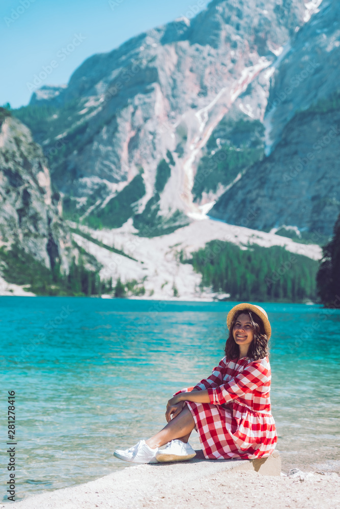 woman sitting on the beach of mountain lake summer season