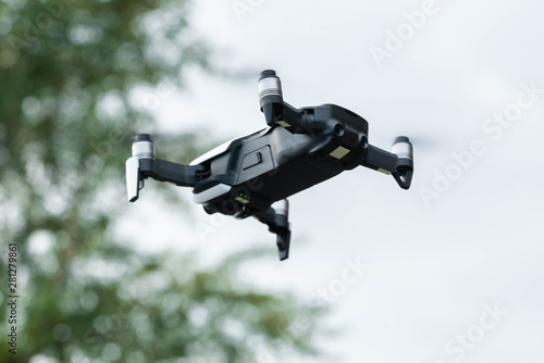 Fototapeta Naklejka Na Ścianę i Meble -  Close up of drone quadcopter inflight. Cityscape background.