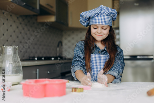 Little girl stir the dough attentively and with pleasure- Image photo