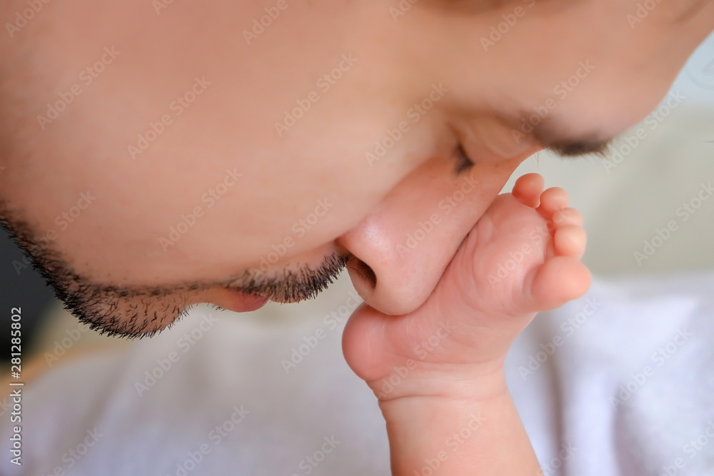Father kisses the baby's leg. Love for the child