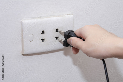 Unplug or plugged in concept, Female hand holding and pull electric plug with copy space