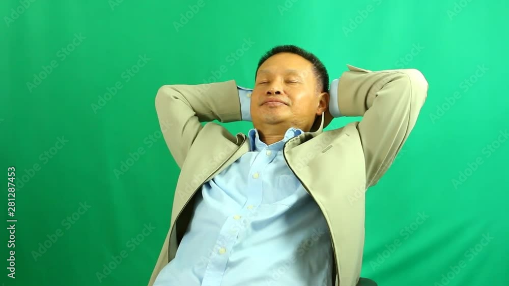 Man relaxing on the chair with green background, in studio Chiangmai Thailand Man relaxing on the chair with green background, in studio Chiangmai Thailand