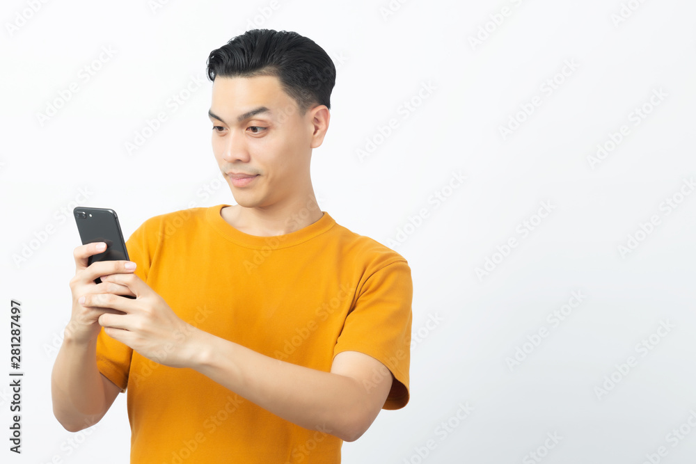 Young happy Asian man reading message from smartphone with copyspace on white background. Young happy Asian man reading message from smartphone with copyspace on white background.