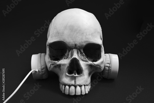 Halloween concept, Weird Skull wearing white headphone with black background