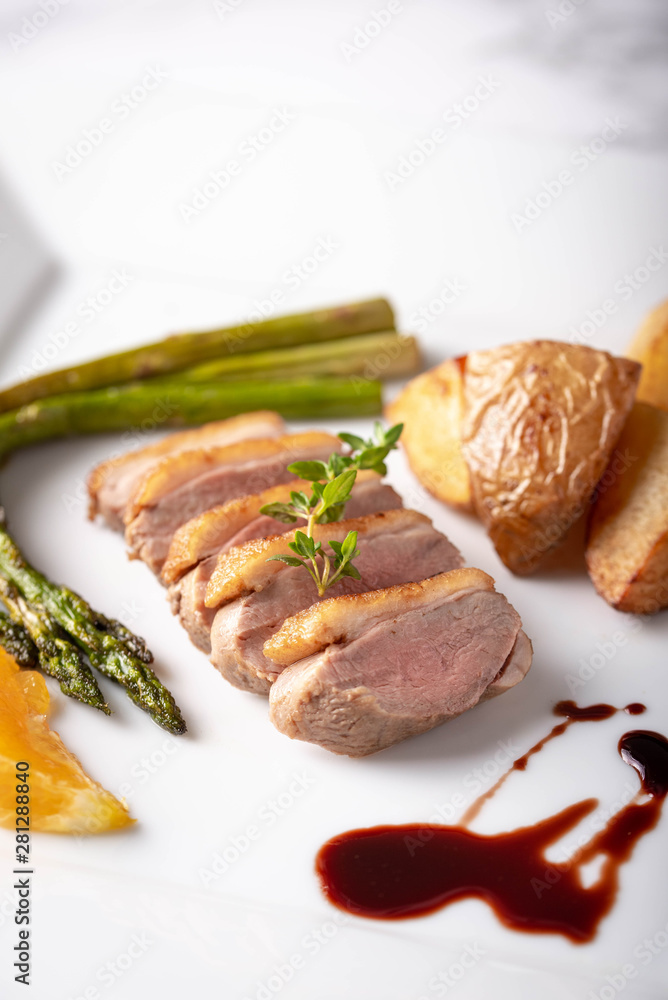 sliced roasted duck with red wine sauce and orange