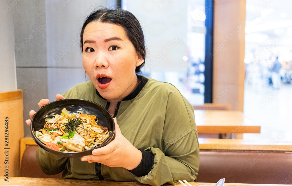 Asian woman feeling excited when she getting food in restaurant, woman holding a plate of Japanese food Asian woman feeling excited when she getting food in restaurant, woman holding a plate of Japanese food