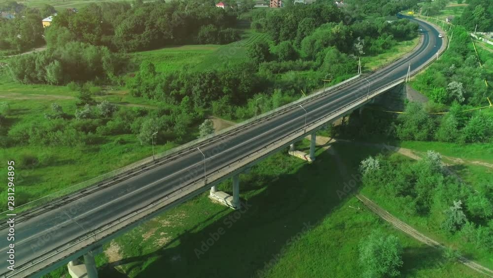 Aerial view of a busy bridge road with moving cars crossing a swamp with water and valley. 4K. Aerial view of a busy bridge road with moving cars crossing a swamp with water and valley. 4K.
