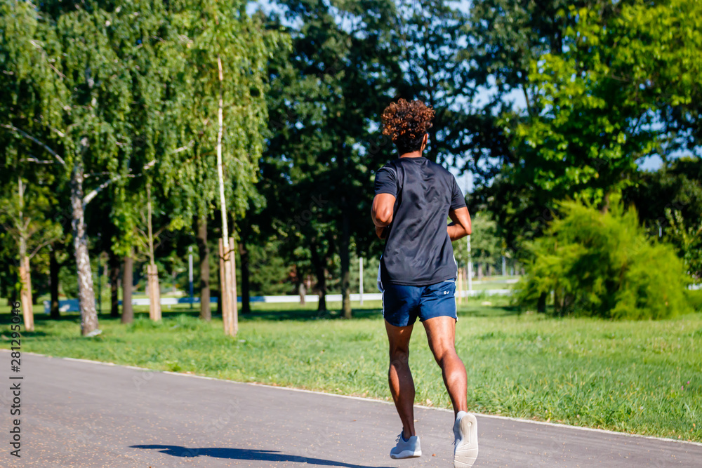 Athletic young man jogging in the park