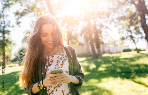 Young woman sending messages with her smartphone photo
