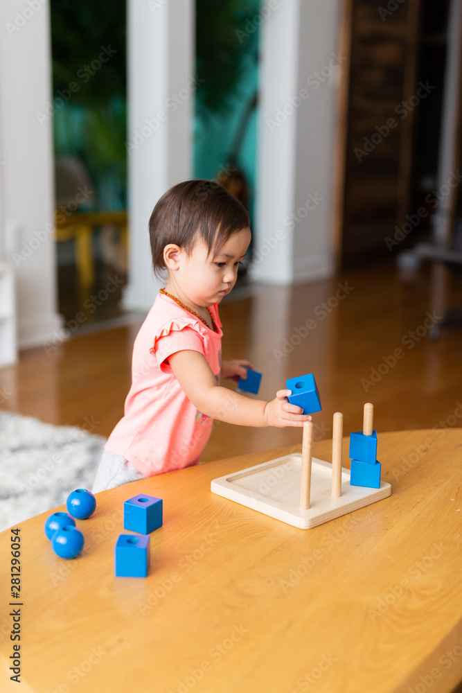 Toddler Girl Playing and Exploring with Montessori Lessons Toddler Girl Playing and Exploring with Montessori Lessons