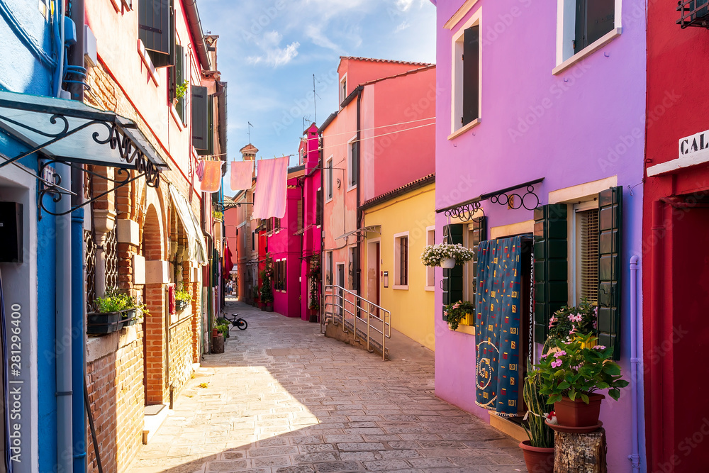 bright colored picturesque buildings at a narrow street , houses of Burano in the evening