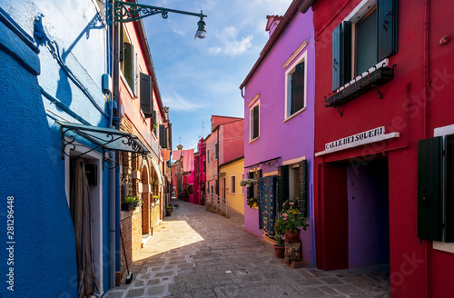 bright colored picturesque buildings at a narrow street , houses of Burano in the evening