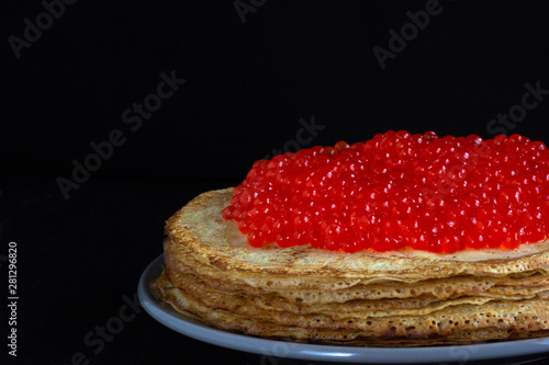 Stack of porous blini with red caviar on the top photo