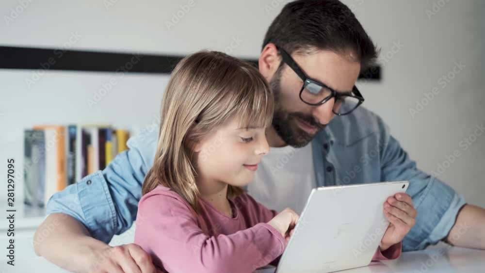 Handsome young father with his daughter using they digital tablet at home. Handsome young father with his daughter using they digital tablet at home.
