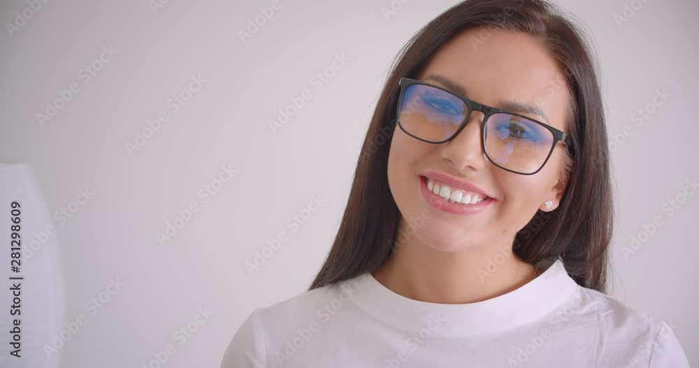 Closeup portrait of young pretty caucasian businesswoman in glasses looking at camera smiling cheerfully with white background Closeup portrait of young pretty caucasian businesswoman in glasses looking at camera smiling cheerfully with white background