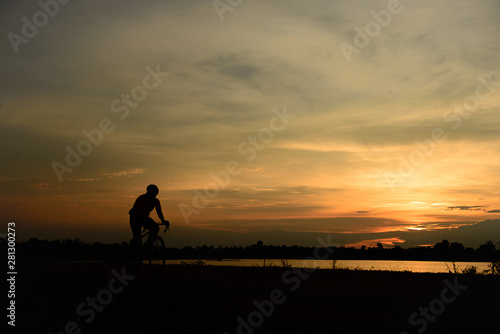 Silhouette of handsome man with bicycle on sunset,sport man concept