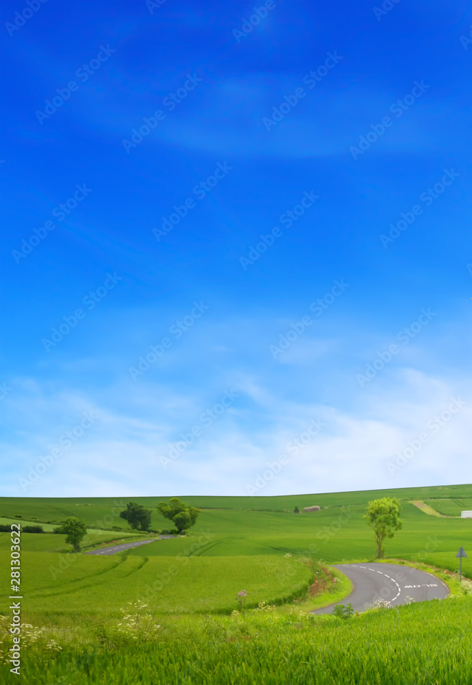A winding road road in the field and blue sky