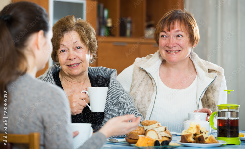 Young female and mature women drinking tea and talking