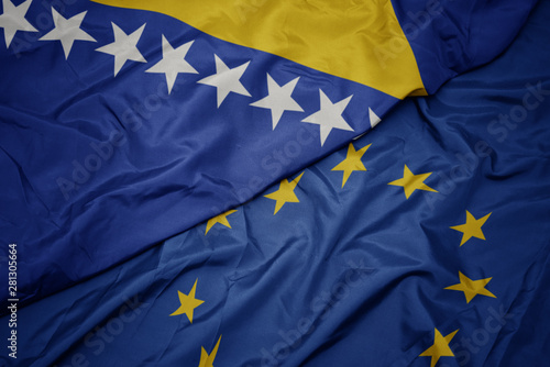 waving colorful flag of european union and flag of bosnia and herzegovina.