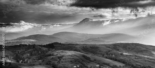 Amazing Carpathian panoramic landscape of misty mountain hills and cloudy sky in black and white. Ukraine.