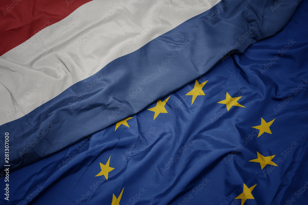 waving colorful flag of european union and national flag of netherlands. waving colorful flag of european union and national flag of netherlands.