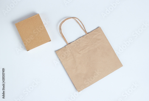 Cardboard box and paper bag on a gray background. Top view.