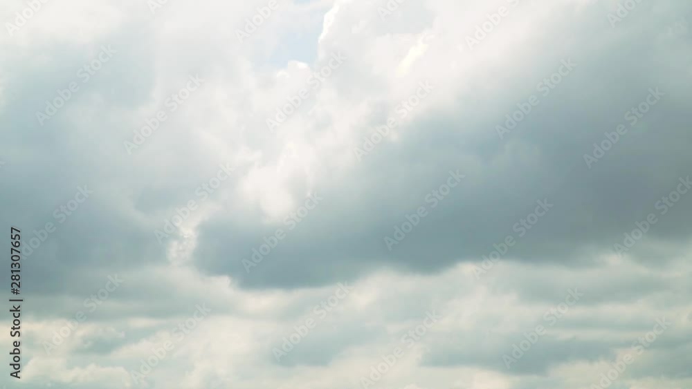 A sky with gray rain clouds through which the sun rays A sky with gray rain clouds through which the sun rays