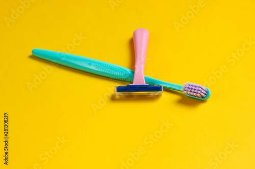 Minimalistic personal care  beauty concept. Plastic razor  toothbrush on yellow background.