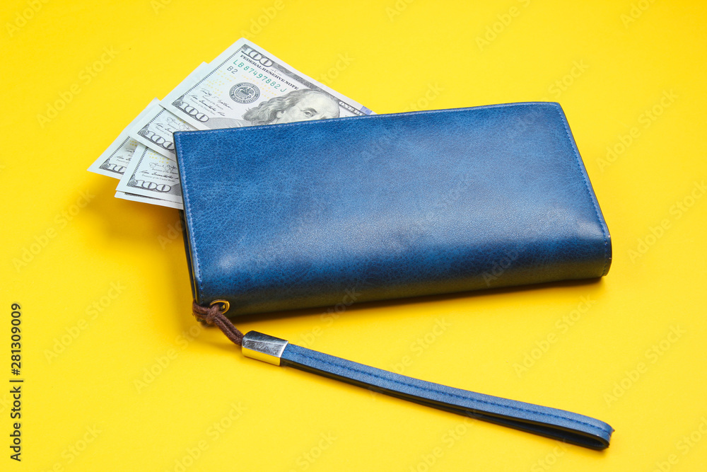 Leather purse and hundred dollar bills on yellow background. Minimalistic financial concept of family budget Leather purse and hundred dollar bills on yellow background. Minimalistic financial concept of family budget