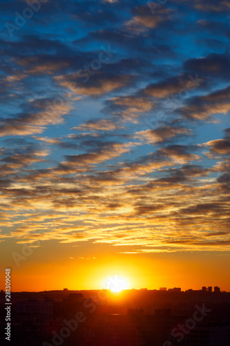 Urban landscape with sunset, cirrus clouds and buildings, vertical view