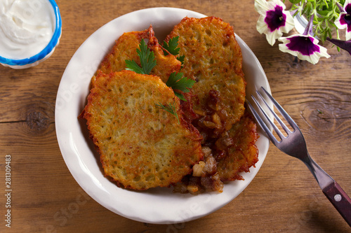 Potato pancakes with bacon and sour cream. Vegetable fritters, draniki - popular dish in many countries