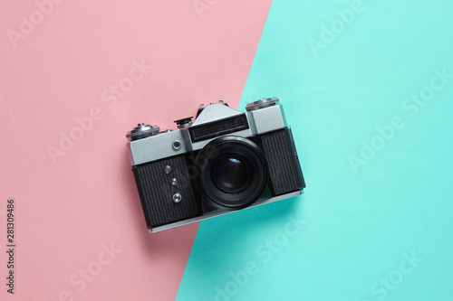 Vintage retro style film camera on pink blue pastel background. Top view