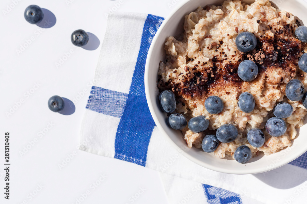 Oatmeal with blueberies and cocoa powder in a round bowl, Close. Top view.