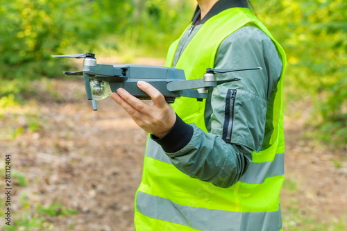 Woman holding Drone quadcopter before forest inspection