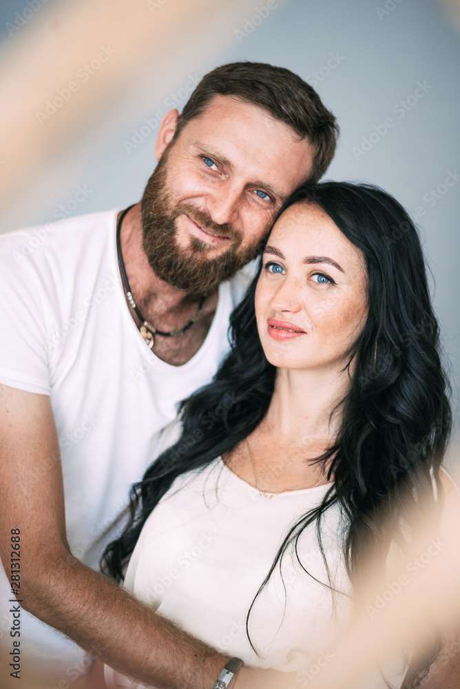 Loving couple woman and man with beard soft light from window