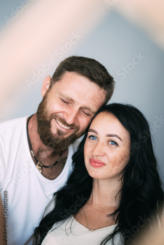 Loving couple woman and man with beard soft light from window