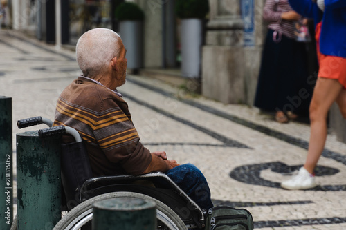 senior man sitting on the wheelchair outdoors. old nomeless  man asking for help. social problems.