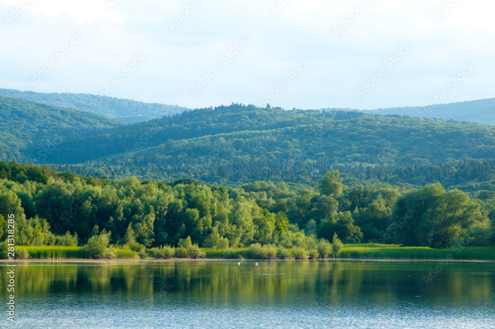 beautiful summer lake against the background of high mountains and blue sky