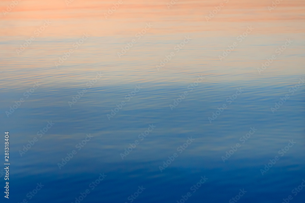 Water surface for background or texture. Sea on sunset. Colorful ripples of the ocean