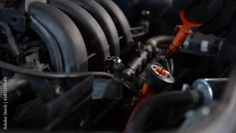 Checking oil level in a car engine close up Checking oil level in a car engine close up
