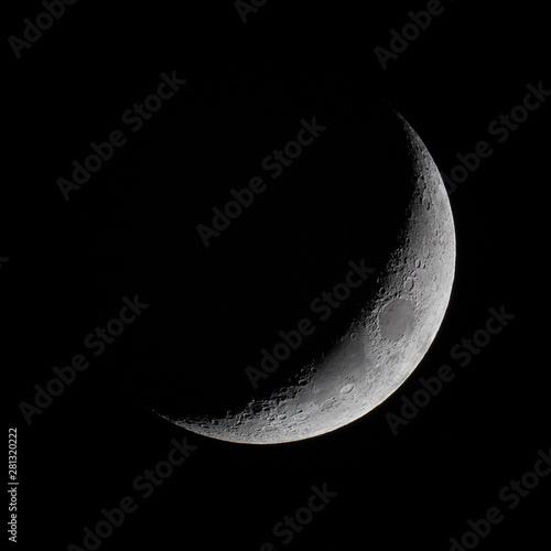 The crescent moon in the night sky.