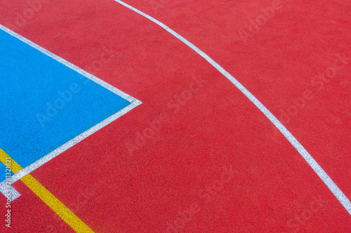 Colorful sports court background. Top view to red and blue field rubber ground with white and yellow lines outdoors © vejaa