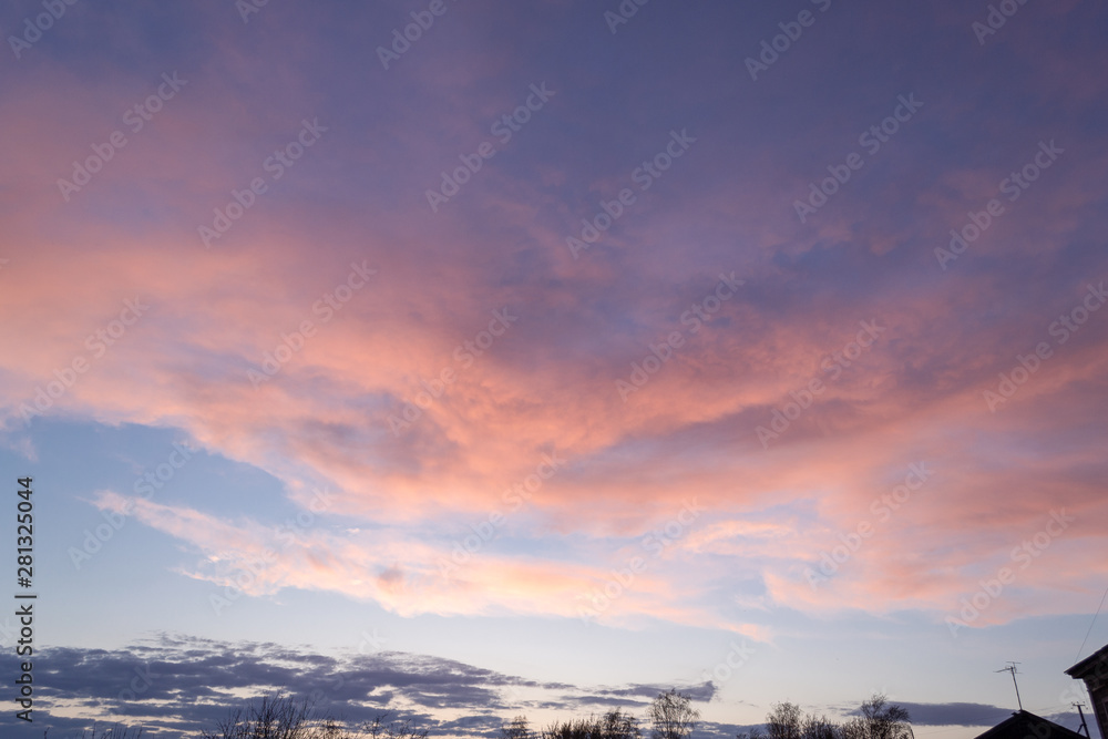 Orange - pink sunset clouds in the blue sky